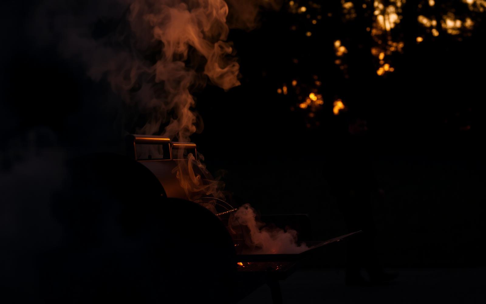 Smoker billowing smoke at dusk